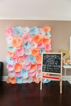 a room with a sign and flowers on the wall next to a chair in front of it