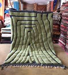 a large green rug is on the floor in a room filled with carpet and fabrics