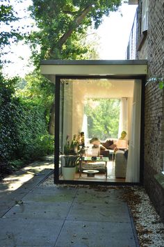 an outdoor living area is shown in the middle of a brick building with glass doors