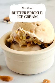 a bowl filled with ice cream sitting on top of a white counter next to nuts