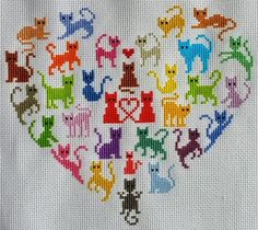 a cross stitch heart with cats and hearts in the shape of an animal's head