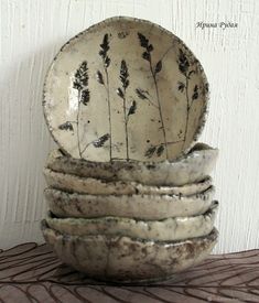 a stack of ceramic bowls sitting on top of a table next to a white wall