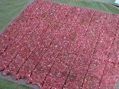 the ground beef is cut into squares and placed on a piece of plastic wrapper