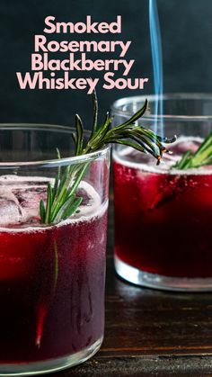 two glasses filled with red liquid and rosemary garnish on the rim, sitting next to each other