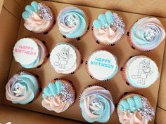 a box filled with cupcakes covered in frosting and decorated with cartoon characters