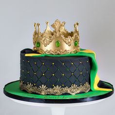 a green and gold cake with two crowns on top