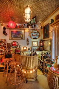 a room filled with lots of wicker furniture and lights on the ceiling above it