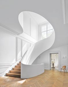 a white spiral staircase in an empty room