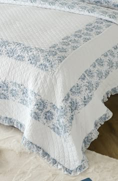 a blue and white quilted bedspread on a bed