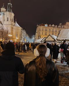 people are walking around in the middle of a crowded city square at christmas time,