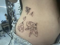 a woman's stomach with tattoos on it and an image of two birds in flight