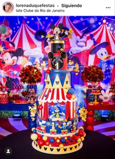 a mickey mouse cake is on display in front of a circus scene with clowns