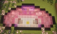 an aerial view of a house in the middle of some pink flowers and grass with trees around it