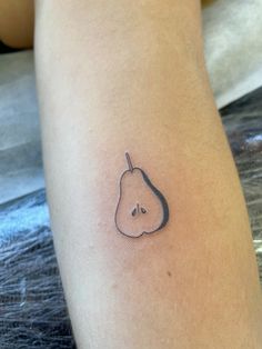 a small pear tattoo on the leg