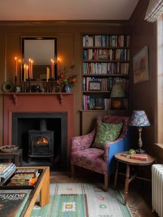 a living room filled with furniture and a fire place in front of a book shelf