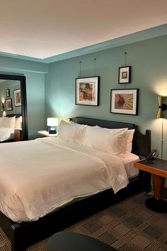 Bedroom with full-length mirror and a hanging headboard artwork wall display in the guestroom at the Romer Hotel in New York City. Hanging Headboard