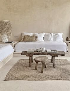 a bed sitting next to a table on top of a rug