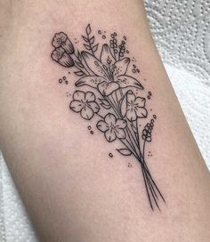 a black and white flower tattoo on the right thigh, with small flowers in it