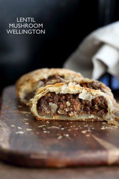 a meat filled pastry sitting on top of a wooden cutting board