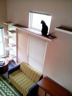 a black cat sitting on top of a window sill in a living room next to a chair