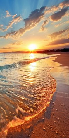 the sun is setting over the ocean with waves coming in from the shore and sand on the beach