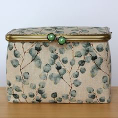 a purse sitting on top of a wooden table next to a pair of green beads