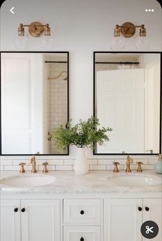 a bathroom with two sinks and mirrors on the wall next to it is a plant in a vase