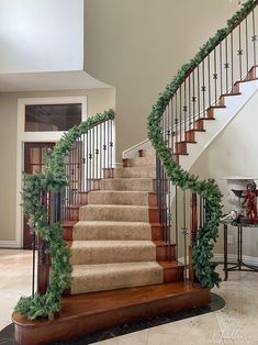 a staircase decorated for christmas with greenery