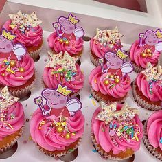 cupcakes with pink frosting and peppa pig decorations on them in a box