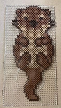 a cross stitched to the side of a piece of plastic with a small animal on it