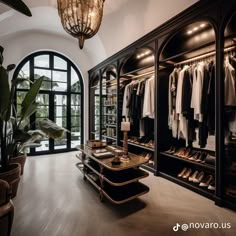 a walk in closet filled with lots of shoes and clothing hanging on shelves next to a large window