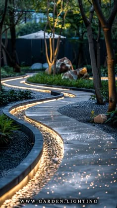 a garden path with lights on the sides and trees in the backgrounnd