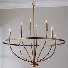 a chandelier with six lights hanging from it's center point in a room