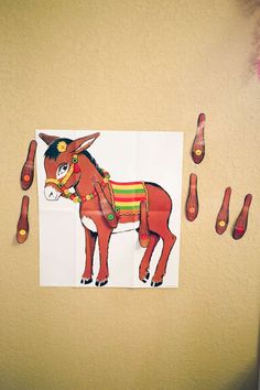 a paper cut out of a donkey on the wall next to some scissors and toothbrushes