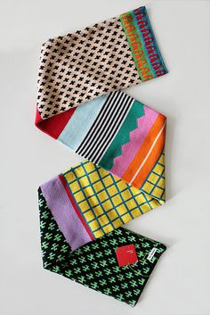 four different colored ties laying next to each other on top of a white countertop