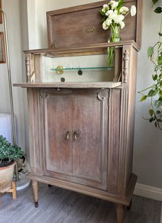 an old wooden cabinet with flowers in the top and bottom drawer on it's side