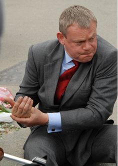 a man in a suit and tie sitting on the ground