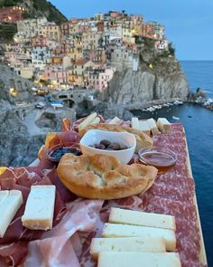 a table topped with lots of food next to the ocean