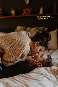 a man and woman laying in bed with their heads on each other's shoulders