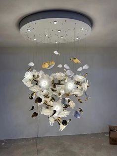 a chandelier with white flowers hanging from it's ceiling in an empty room