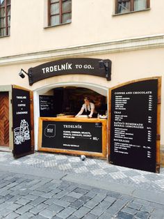 the outside of a restaurant with menus on it's walls and signs in front