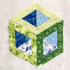 an origami cube with blue and green designs on it