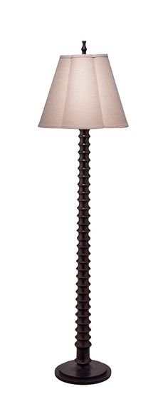 a lamp that is on top of a white surface with a light shade over it