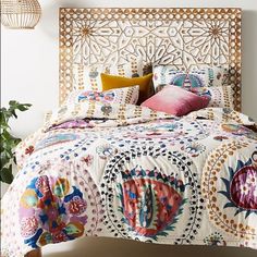 a bed with an intricate headboard and colorful pillows