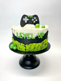 a cake that is sitting on top of a stand with a video game controller in it