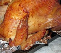 a roasted turkey is wrapped in foil and ready to be cooked on the stove top