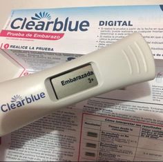 a digital thermometer sitting on top of some papers with other items in front of it