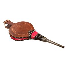 an old style wooden instrument with red and black accents