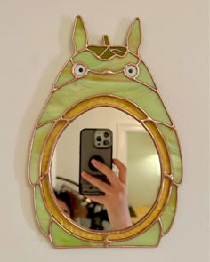 a person taking a selfie in front of a mirror with a cat design on it