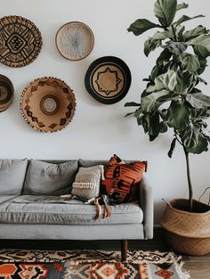 a living room filled with furniture and lots of plates hanging on the wall above it